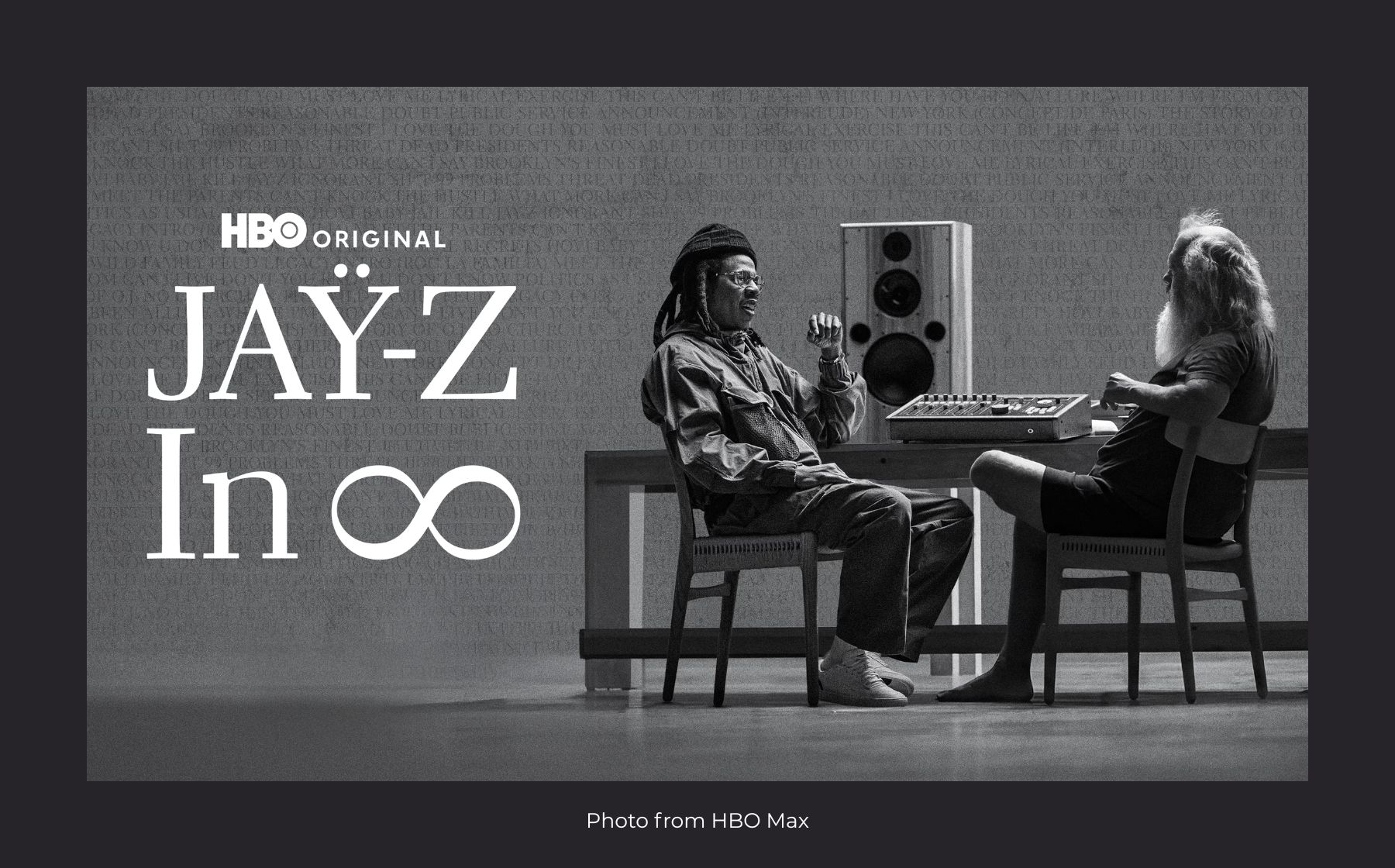 Jay-Z and another man sit facing each other in a minimalist studio with audio equipment. Text reads “HBO Original JAY-Z In ∞”. Photo from HBO Max.